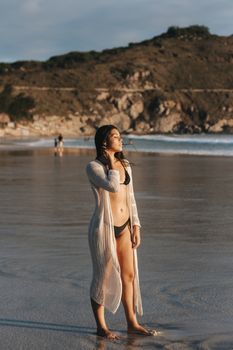 A woman in a bikini enjoys a sunny day at Arraial do Cabo beach, Brazil.
