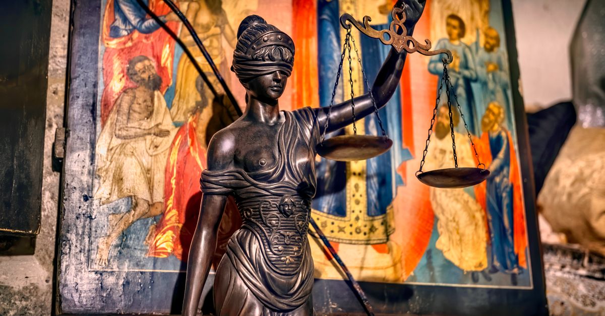 Una estatua con los ojos vendados que representa la justicia sosteniendo una balanza, en un fondo ornamentado en Jerusalén.
