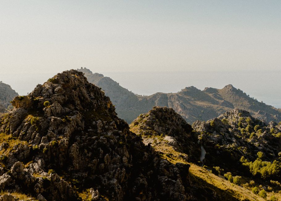 Scenic view of craggy mountains and lush greenery under a clear sky near Palma, Spain.