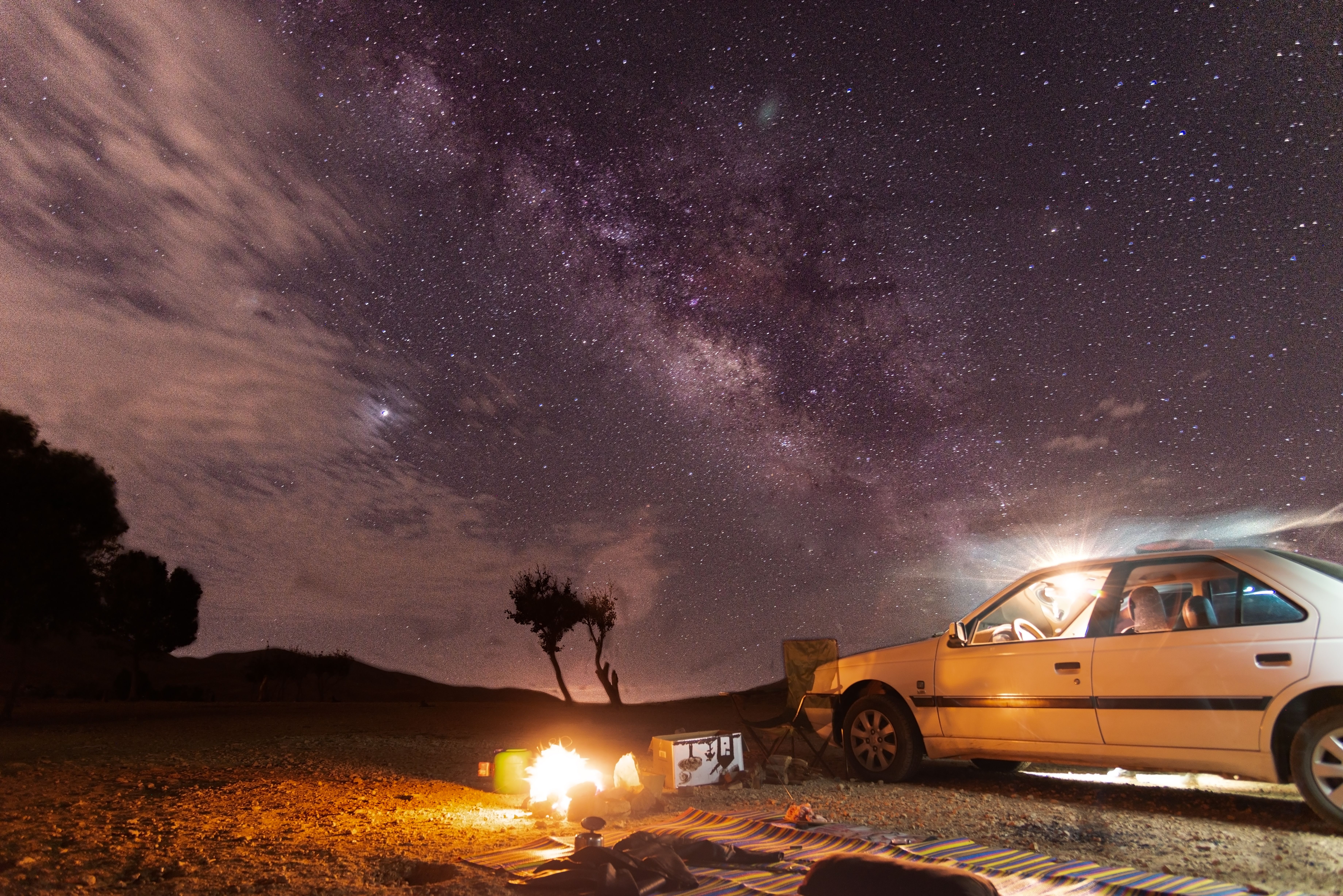 Experience a mesmerizing night under the Milky Way with a cozy campfire and distant stars in Borouje