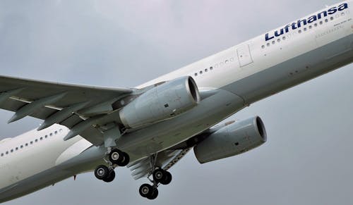 Modern aircraft flying in cloudy gray sky