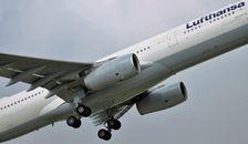 Modern aircraft flying in cloudy gray sky