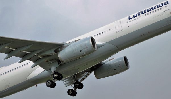 Modern aircraft flying in cloudy gray sky