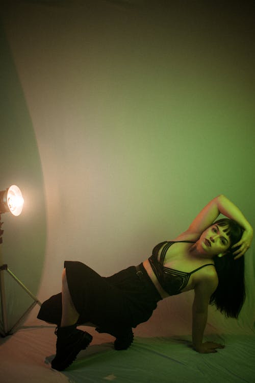 Sensual young woman touching head in neon light
