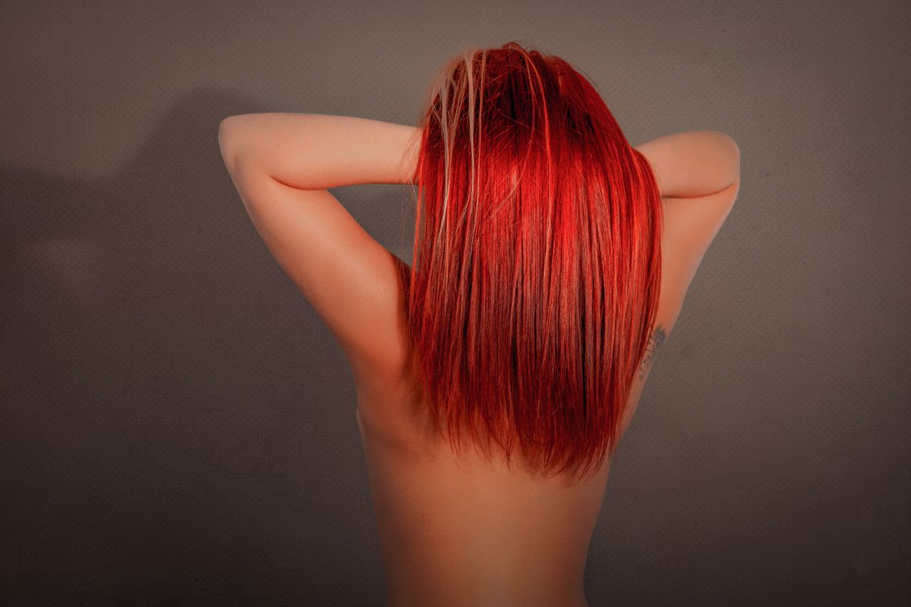 striking studio portrait of a woman showcasing vibrant red hair posing