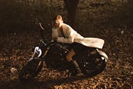 Stylish female sitting on motorbike in park