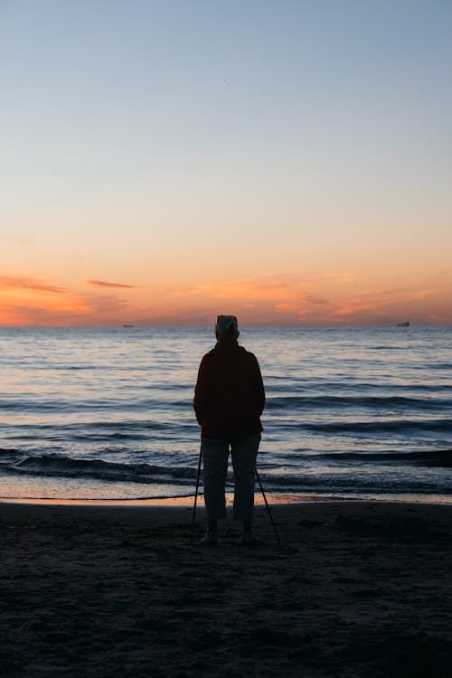 A Silhouette of Man Standing on the Beach
