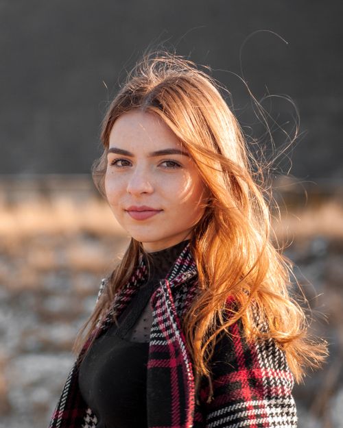 Free Close-up portrait of a smiling woman with long blonde hair in a natural outdoor setting. Stock Photo