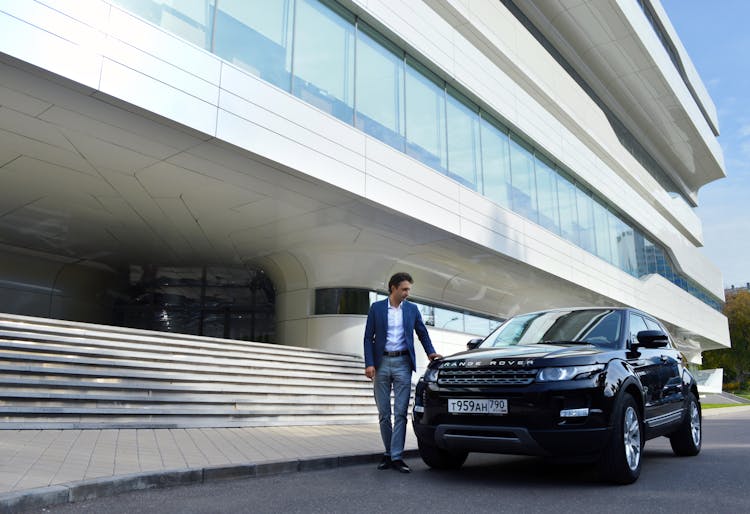 Well Dressed Man Standing Near New Black Car In City