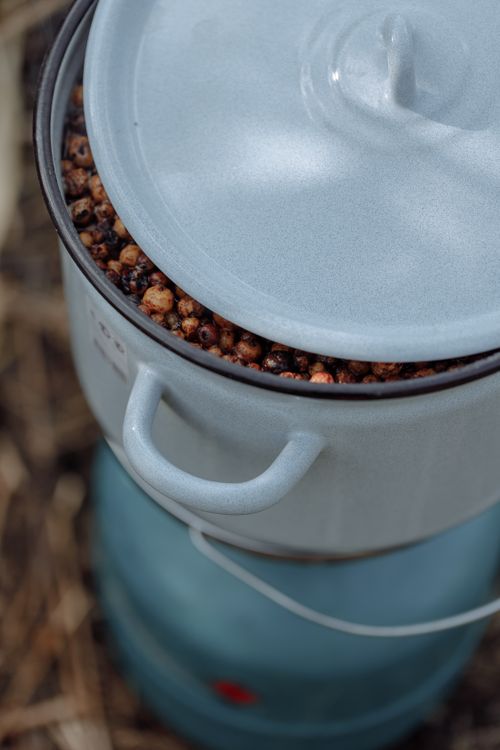 Free A uniquely angled view of a pot filled with roasted nuts, showcasing rustic cooking. Stock Photo