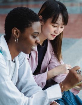 两位女性在户外专注而快乐地一起学习