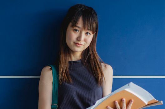 一位平静迷人的年轻女子手持笔记本，散发着宁静与专注学习的气息