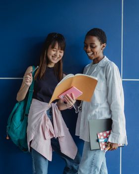 学习期间，两名年轻女子笑着分享笔记