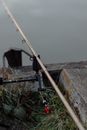 特写镜头聚焦于河岸上的鱼竿和设备，展现了宁静的户外钓鱼场景