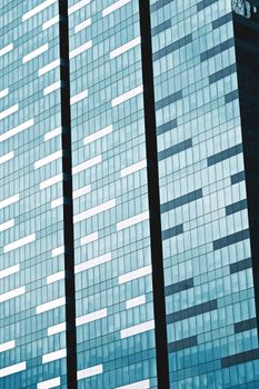 Close-up of a modern skyscraper's glass facade in Singapore, showcasing architectural patterns and reflections.