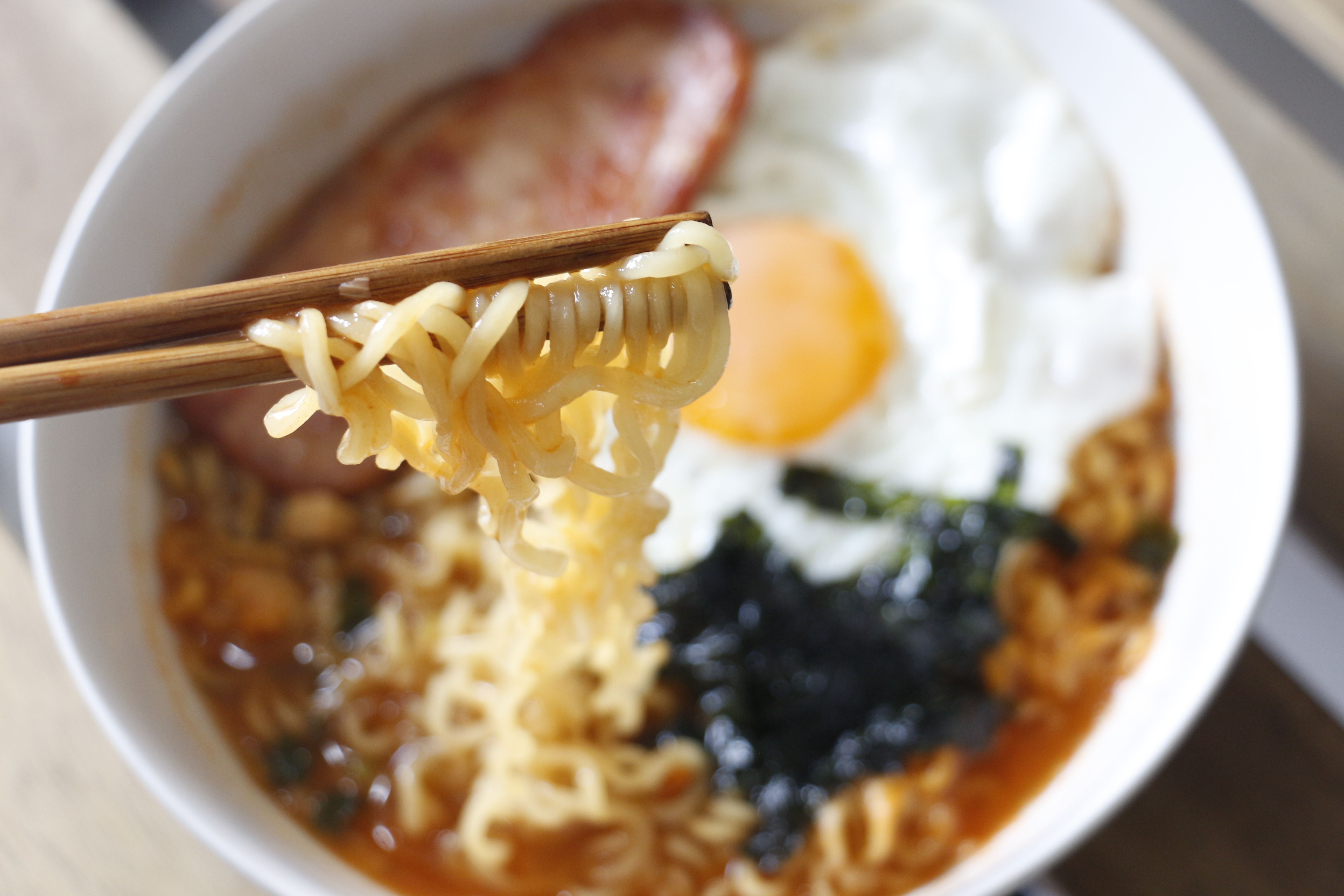 Close-up of traditional Asian ramen with egg, bacon, and seaweed, captured with Canon EOS 700D.