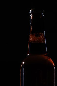 特写镜头中，啤酒瓶的剪影被设置在黑暗的背景上