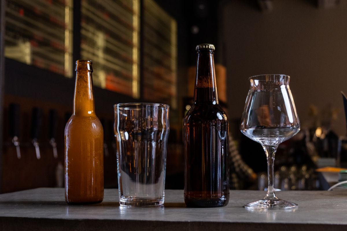 Bottiglie e bicchieri di birra su un tavolo, immagine stock