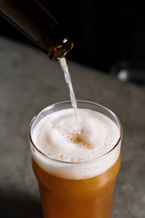 A Person Pouring Beer in the Glass