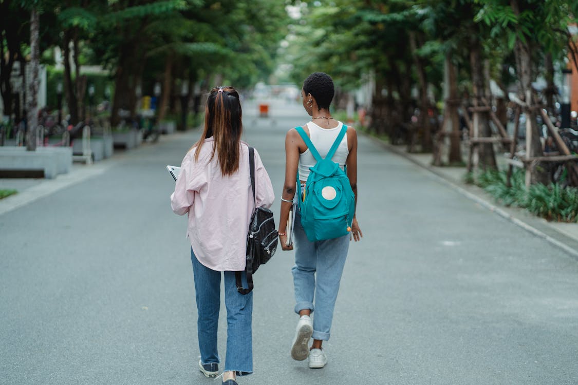 Multiethnic female friends walking down street and chatting