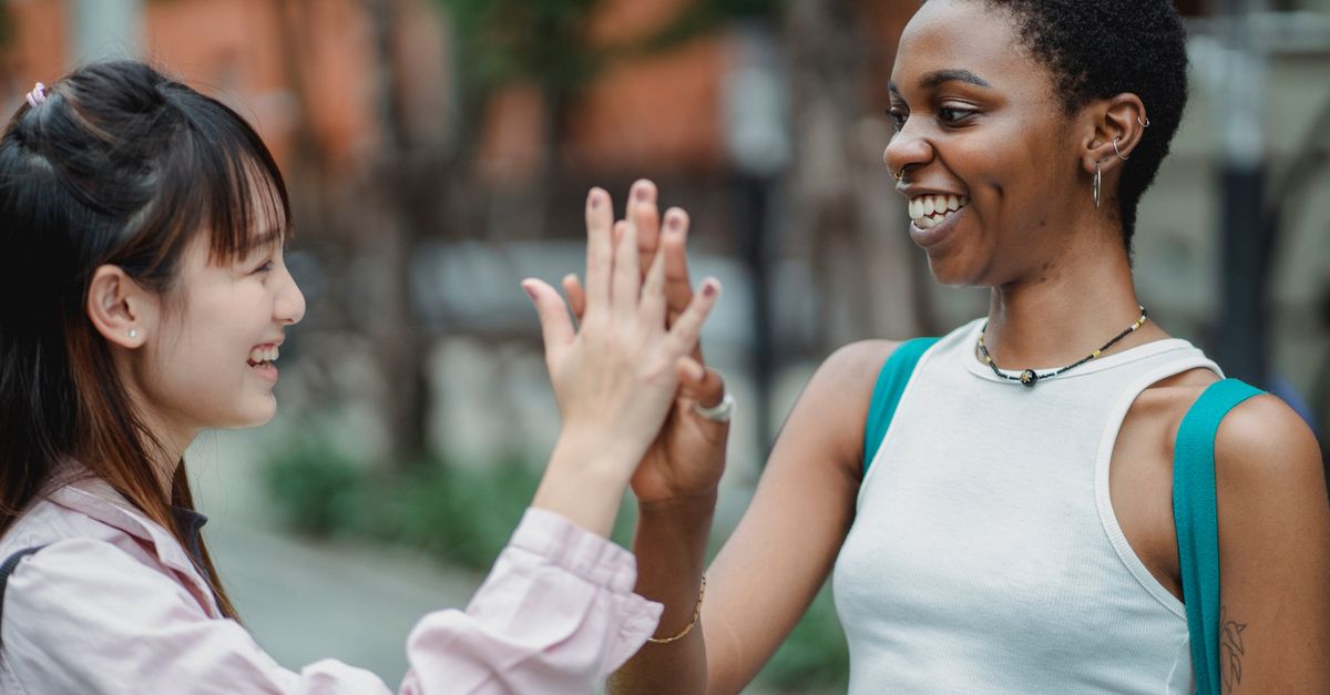 friends laughing together outside a neighborhood gym entrance