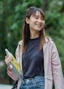 Happy Asian female student waling in park