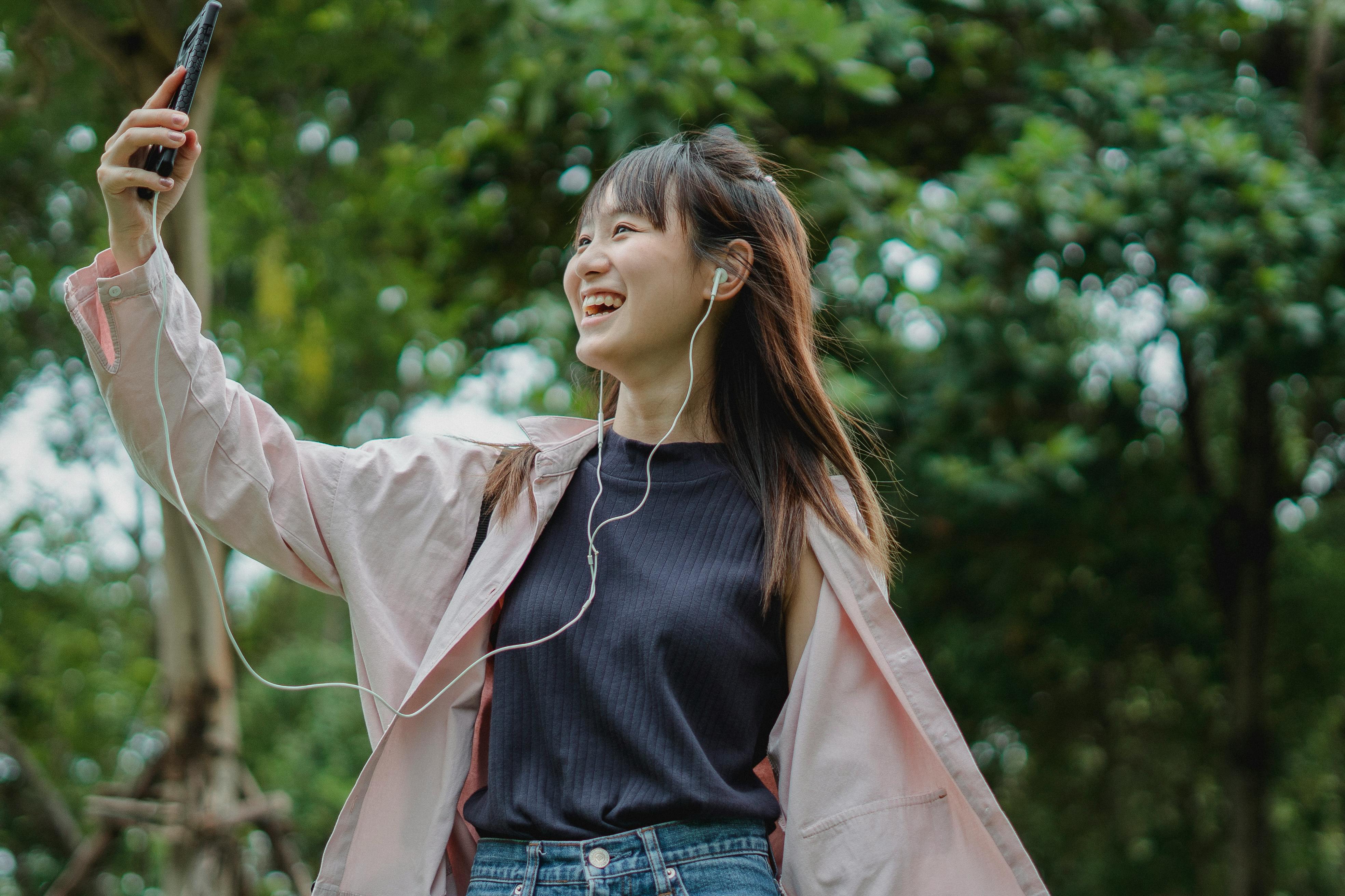 happy woman with smartphone and earphones