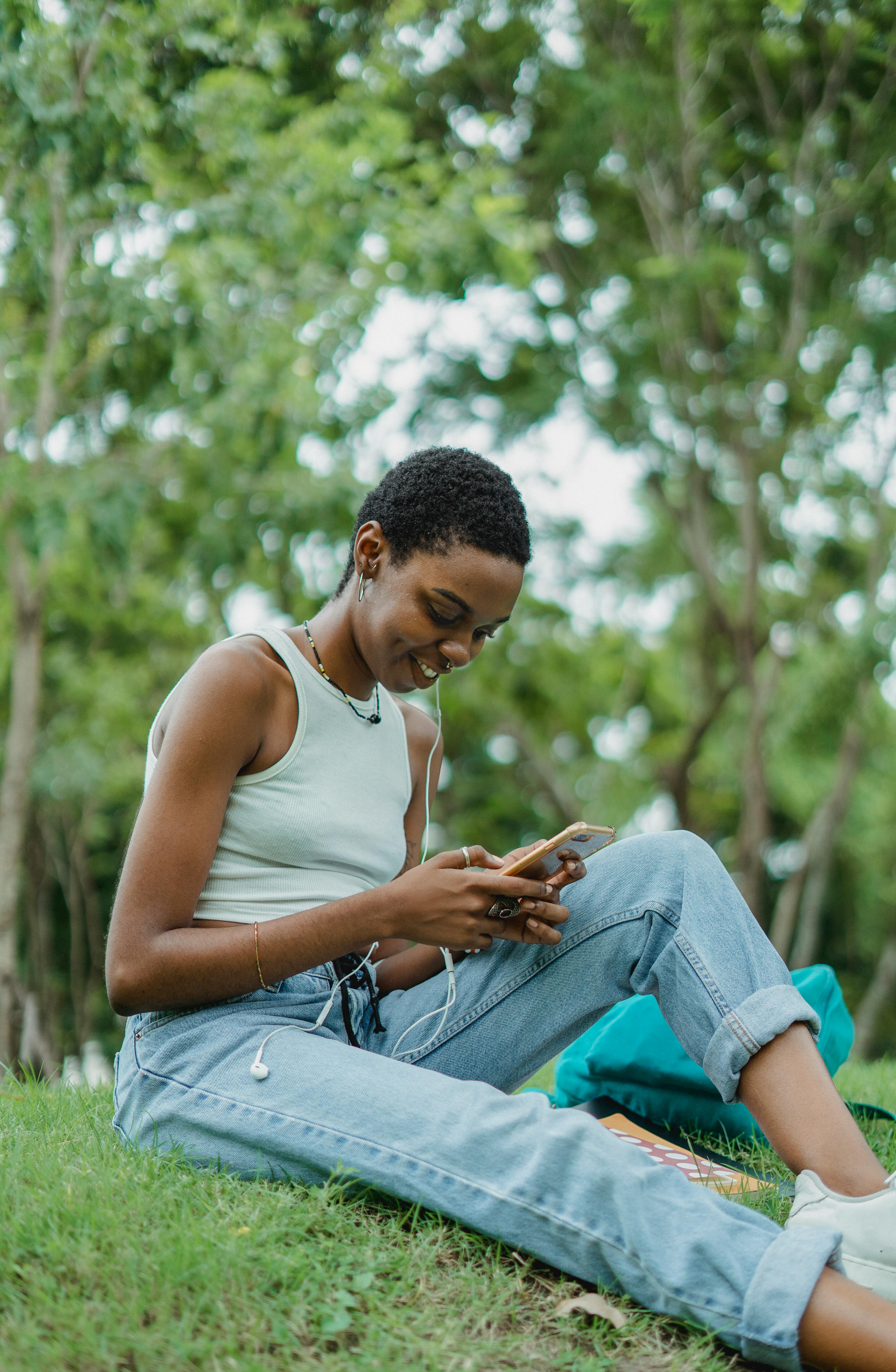 black woman with smartphone in park