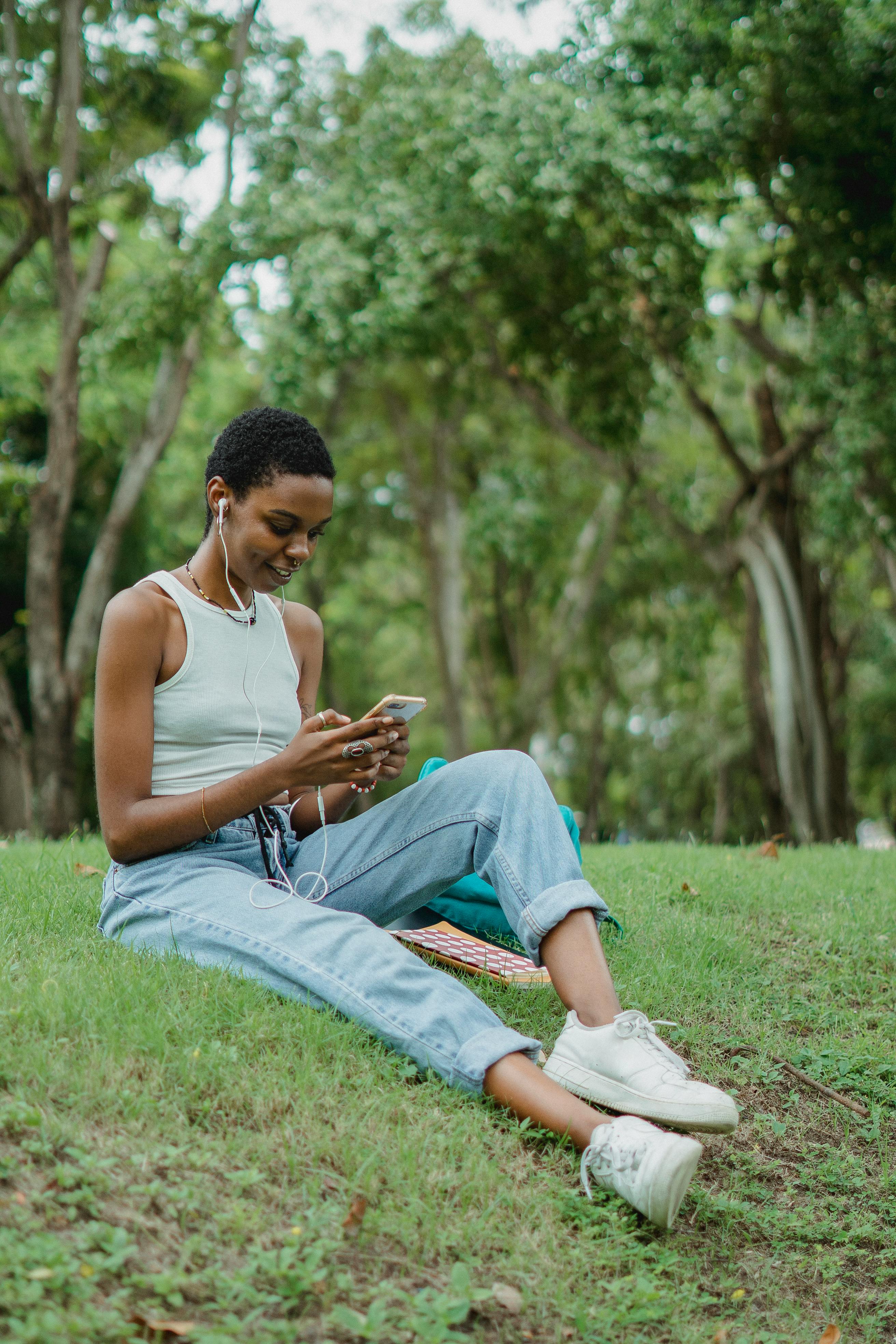 ethnic woman video calling in park