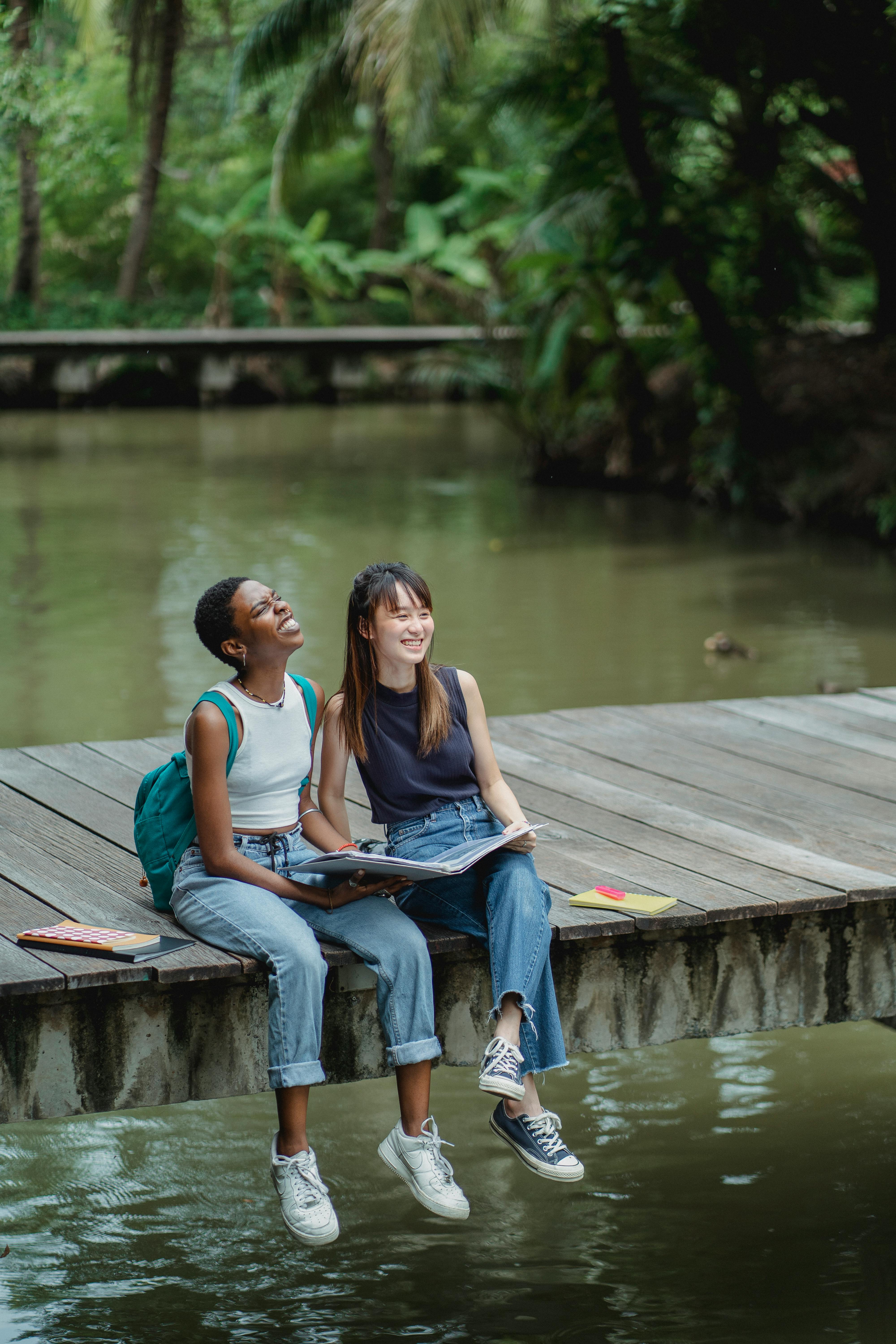 happy multiracial friends on wooden bridge