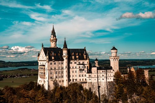 Free Majestic aerial view of Neuschwanstein Castle under a clear blue sky in Bavaria, Germany. Stock Photo