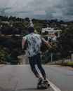 南非比勒陀利亚郊区街道上，一名男子滑着滑板远去的背影