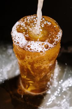 金色啤酒倒入玻璃杯，泡沫溢出的高品质特写