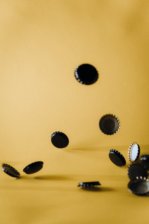 Безкоштовне стокове фото на тему «вертикальні постріл, жовтий фон, ковпачки для пляшок»