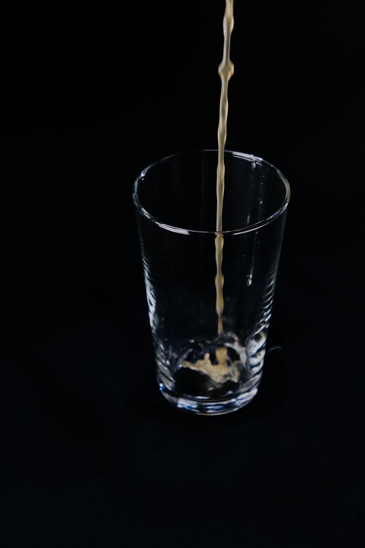 Pouring Yellow Liquid On Clear Glass