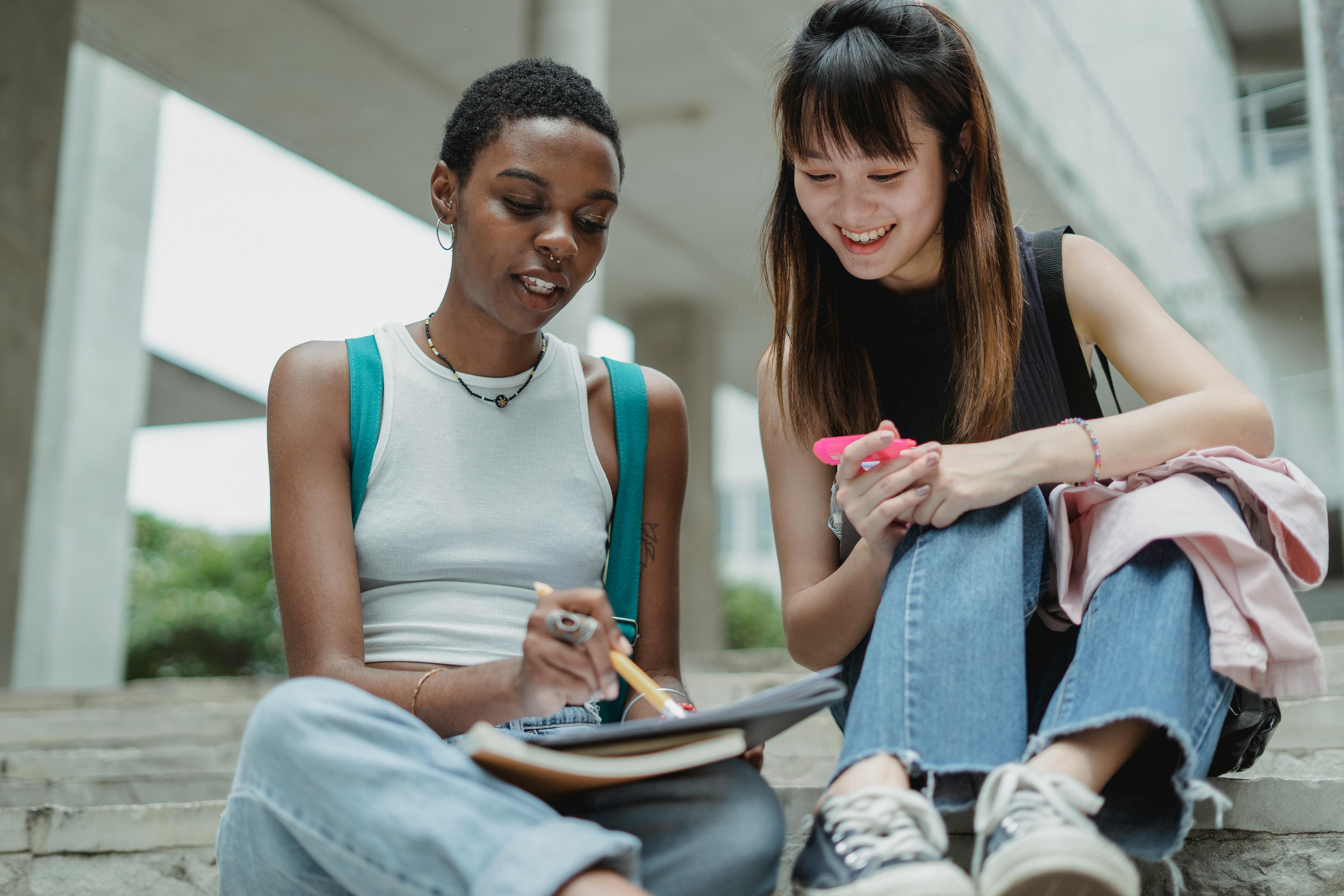 cheerful multiethnic students with notebook