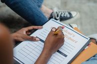 Crop student writing report with pencil
