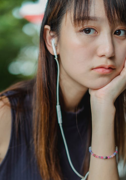 戴着耳机在手上倾斜的年轻女子