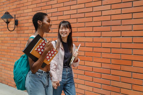 Positive young multiracial students talking after lessons