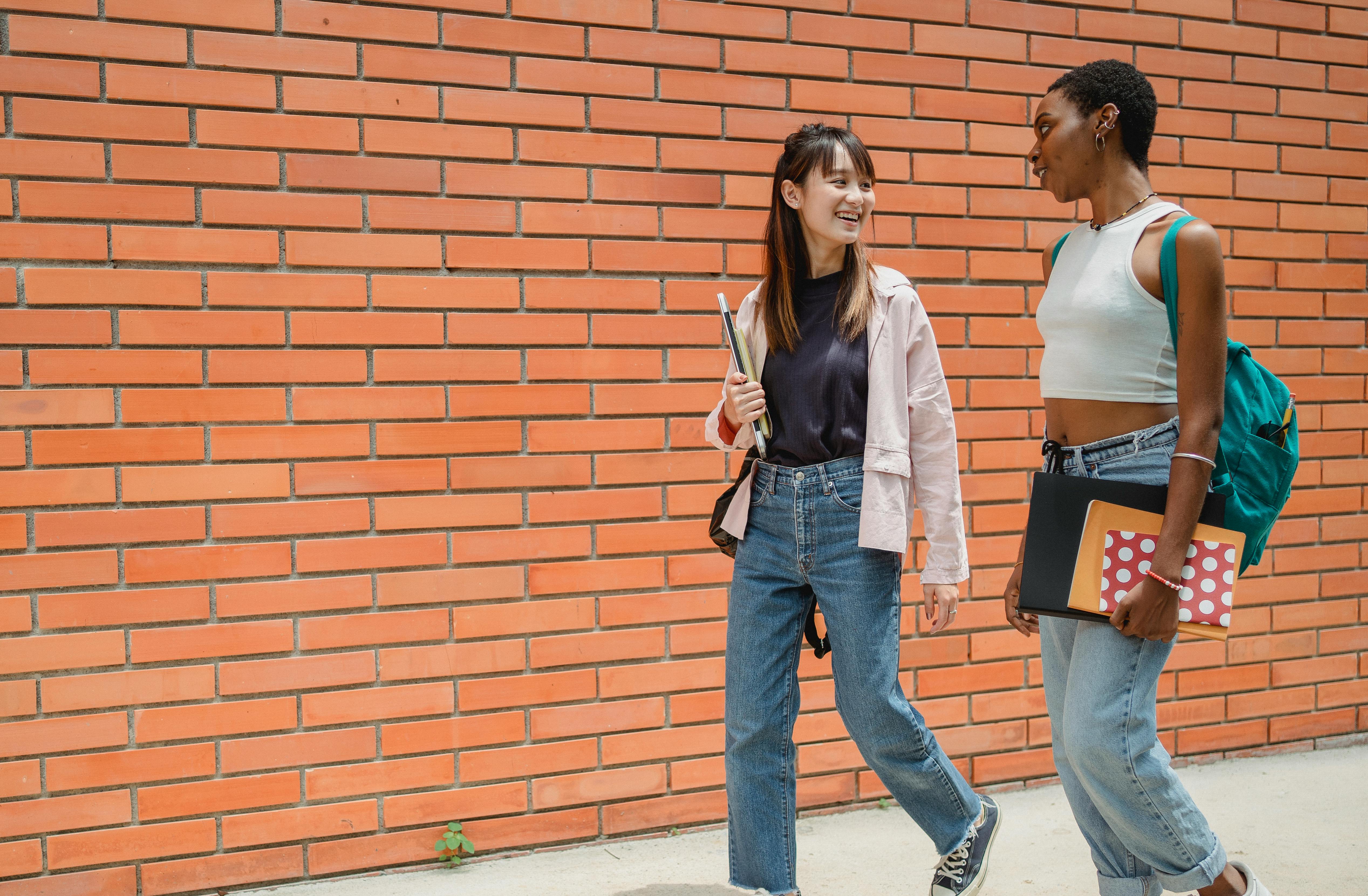 young multiethnic female students communicating during break