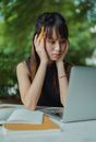 一名年轻女子在户外咖啡馆专注地用笔记本电脑学习
