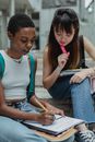 两名年轻女性在户外合作学习，象征着团队合作与教育