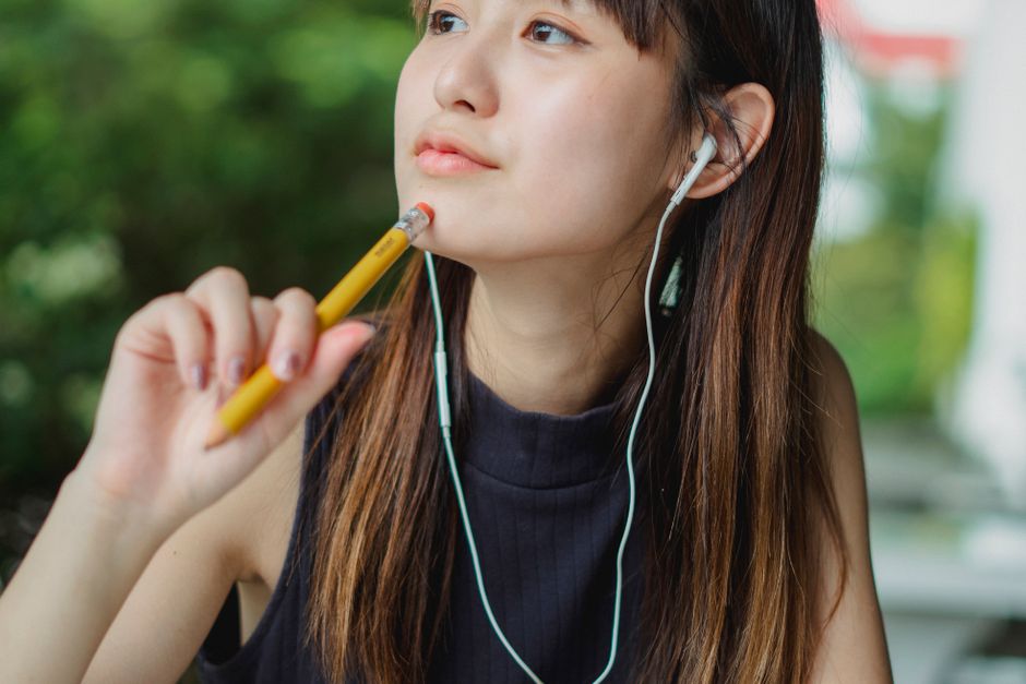 Young Asian Woman Listening To Music With Earphones Outdoors Free young-asian-woman-listening-to-music-with-earphones-outdoors-free