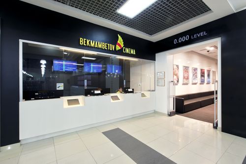 Free Interior view of a modern cinema box office with digital displays and sleek design, creating an inviting atmosphere. Stock Photo