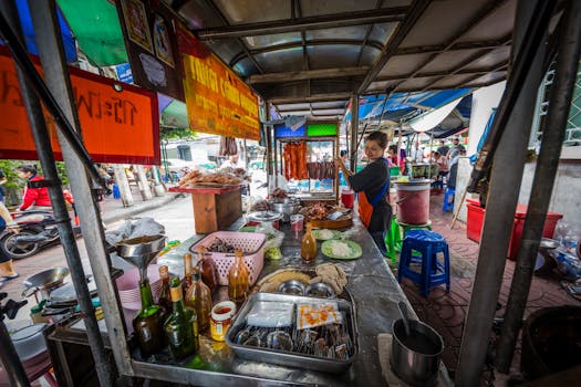 A vibrant street vendor prepares traditional Asian street food at a bustling outdoor market.
