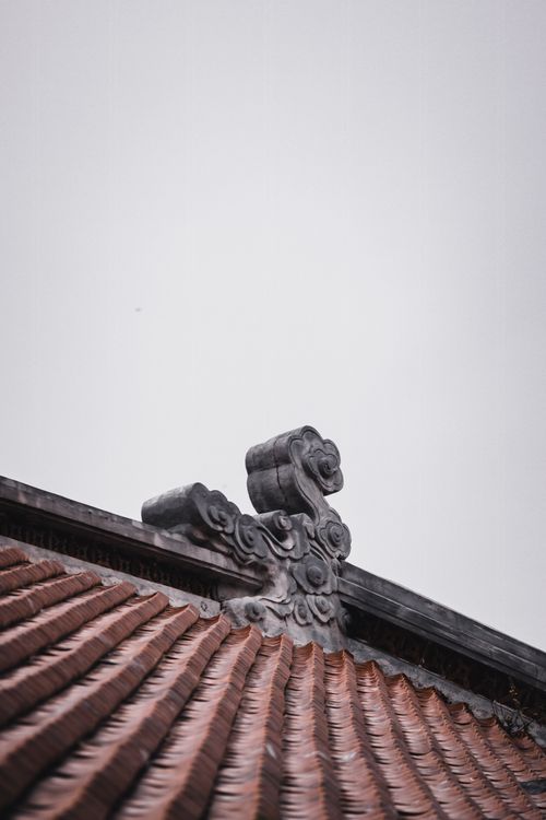 Free Close-up of a traditional Vietnamese roof sculpture against a clear sky in Ho Chi Minh City. Stock Photo
