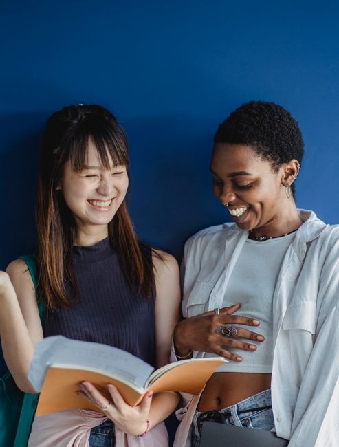 Two young women enjoying each other's company while reading together.