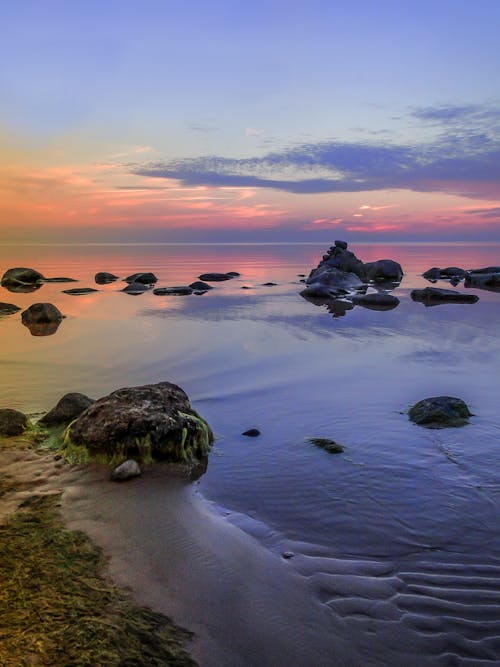 Rock Formation on Body of Water during Sunset