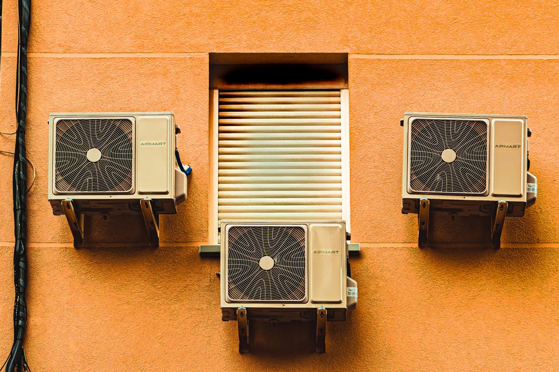 Building exterior wall with multiple window air conditioner units.