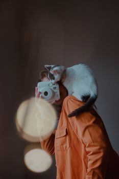 一只顽皮的猫趴在肩上，协助在室内拍照，场景温馨舒适